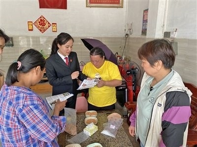  圖⑤：龍圩區(qū)法院法官到群眾家中開展法治宣傳。資料圖片