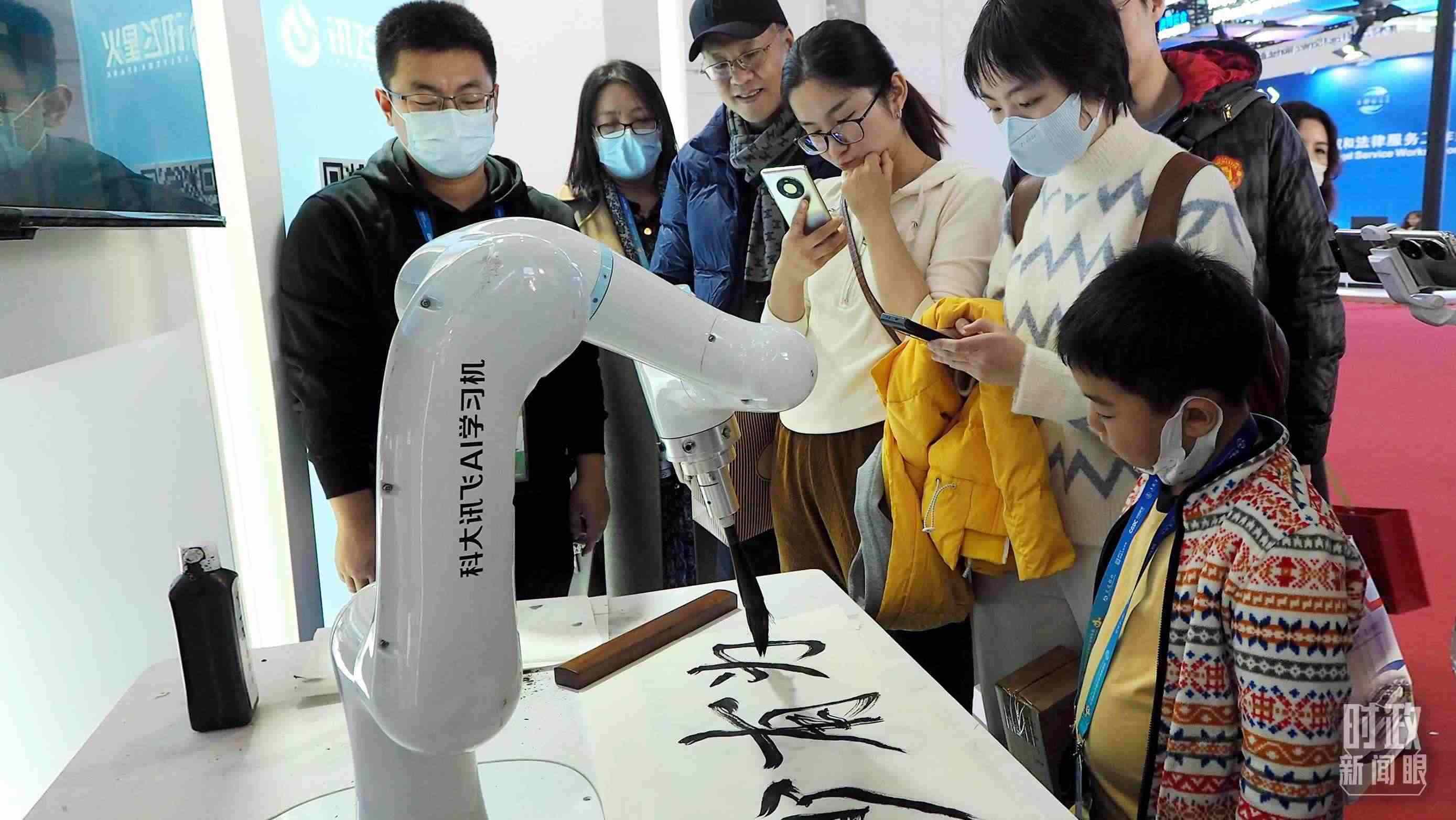 △觀眾在首屆鏈博會(huì)上體驗(yàn)AI書(shū)法機(jī)器人。