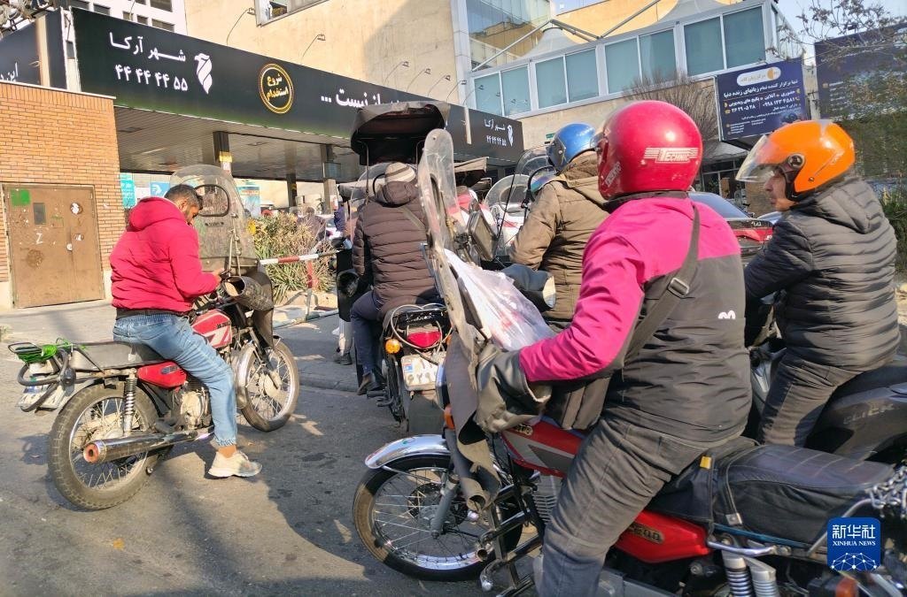12月18日，摩托車在伊朗首都德黑蘭的一家加油站外等待加油。新華社記者 沙達(dá)提 攝