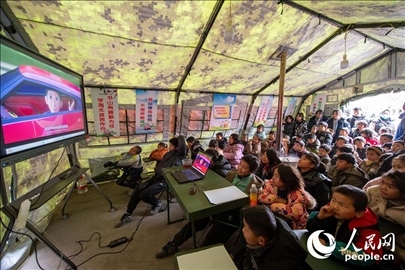 12月22日，在積石山縣大河家鎮(zhèn)大河村安置點，陸軍76集團軍某旅搭建的“臨時學?！眱?nèi)，小朋友正在看動畫片。人民網(wǎng)記者 翁奇羽攝