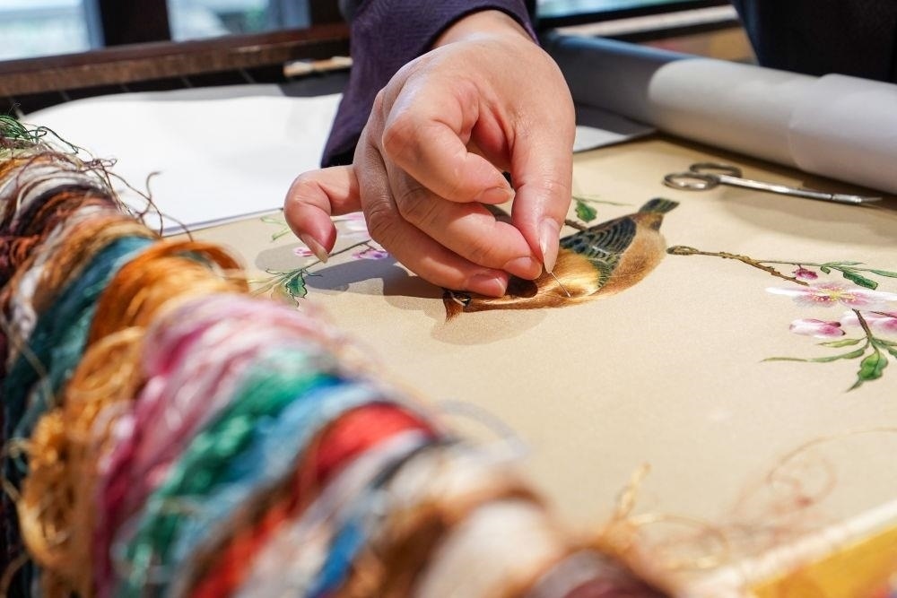 △2023年7月6日，盧建英在江蘇蘇州平江路的工作室內(nèi)刺繡。