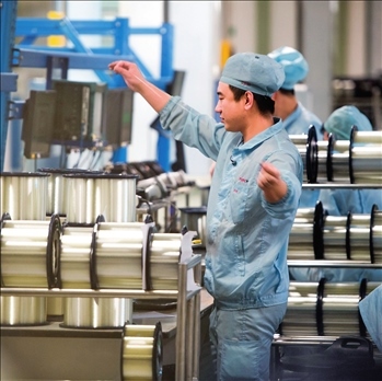 在位于武漢的長飛光纖光纜股份有限公司光纖生產(chǎn)車間內(nèi)，工作人員對光纖進(jìn)行檢測（資料圖片）。肖藝九攝/本刊