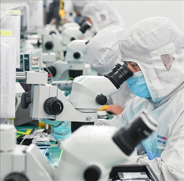 在位于武漢中國光谷的光電器件研發(fā)制造商——武漢光迅科技股份有限公司生產(chǎn)車間內(nèi)，技術(shù)人員在光模塊生產(chǎn)線作業(yè)（2023年4月11日攝）。程敏攝/本刊