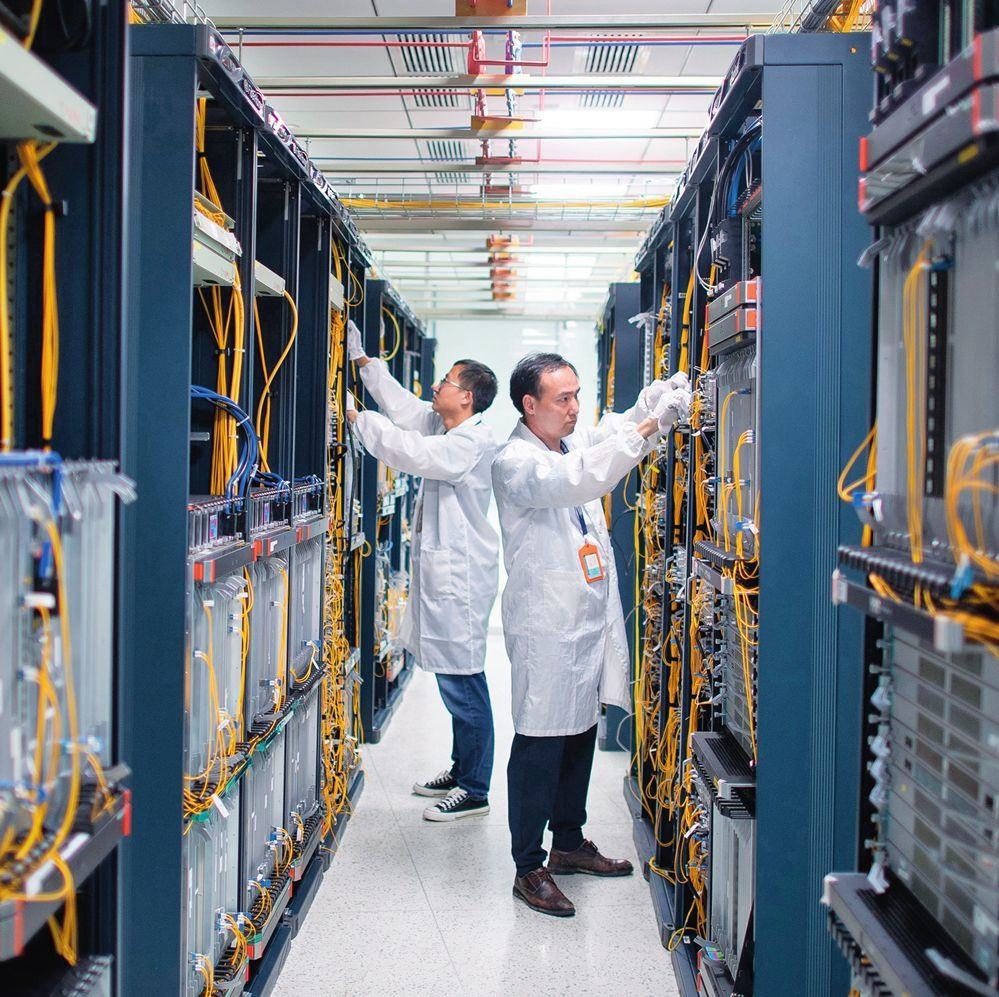 在位于武漢中國光谷的光電器件研發(fā)制造商——武漢光迅科技股份有限公司生產(chǎn)車間內(nèi)，技術(shù)人員在光模塊生產(chǎn)線作業(yè)（2023年4月11日攝）。程敏攝/本刊