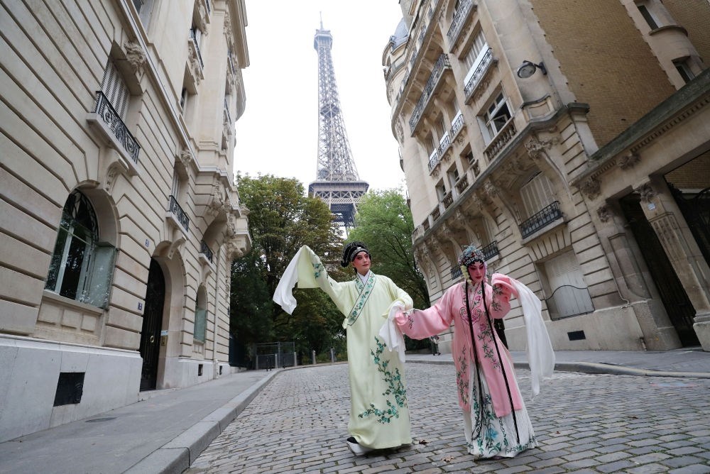 2023年9月13日，江蘇省演藝集團(tuán)昆劇院院長施夏明（左）和江蘇省演藝集團(tuán)昆劇院國家一級演員孔愛萍在法國巴黎埃菲爾鐵塔附近參加昆曲快閃。新華社記者 高靜 攝