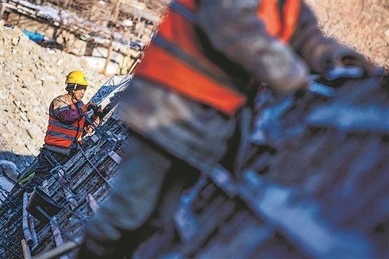 1月3日，房山區(qū)，工人正在雙泉河修筑堤壩。