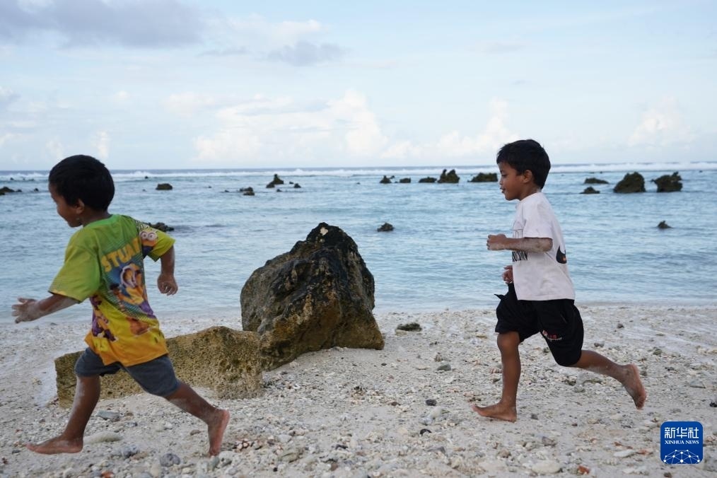 1月20日，兒童在瑙魯海邊嬉戲。新華社記者 王申 攝