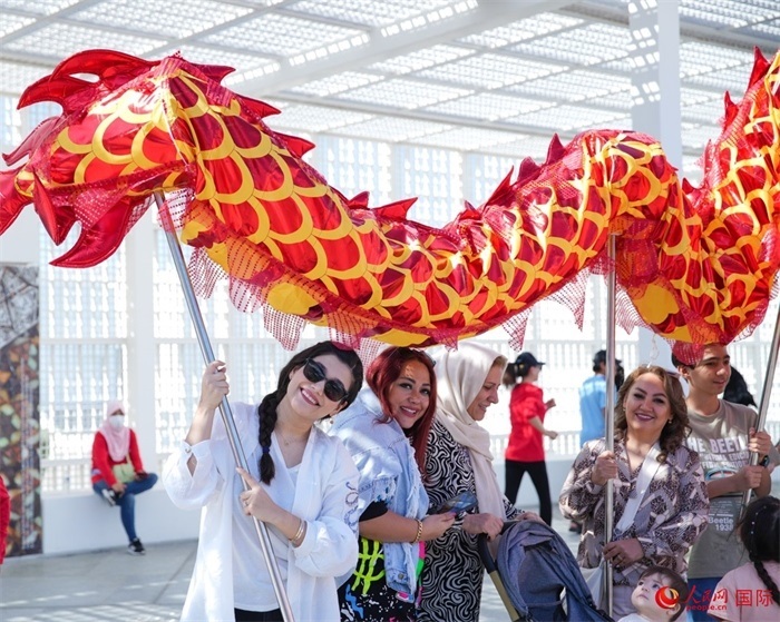 游客體驗舞龍。 人民網(wǎng) 塔里克·易卜拉欣攝