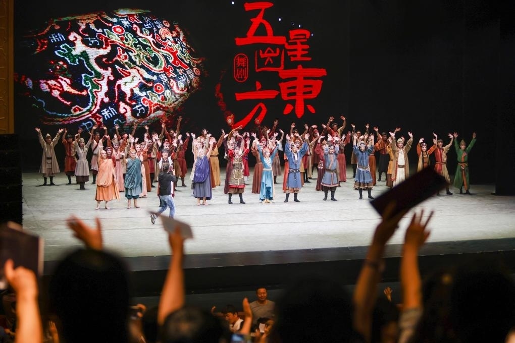 2023年7月31日，新疆和田地區(qū)新玉歌舞團在烏魯木齊京劇院演出舞劇《五星出東方》后和觀眾互相揮手致意。這場演出是第六屆中國新疆國際民族舞蹈節(jié)的參演劇目之一，曾榮獲國家“文華獎”等。新華社記者 郝昭 攝