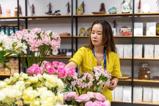 2023年7月1日，在位于湖南省長沙市的湖南高橋大市場，中非經(jīng)貿(mào)博覽會常設(shè)展館展區(qū)肯尼亞館工作人員在整理產(chǎn)自非洲的鮮花。新華社記者 陳思汗 攝