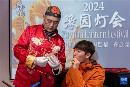 1月28日，在上海豫園舉行的民俗活動上，美國馬斯卡廷中學(xué)學(xué)生在非遺傳承人的指導(dǎo)下吹糖偶。 新華社記者 王翔 攝