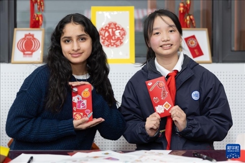 1月28日，美國馬斯卡廷中學(xué)學(xué)生（左）和復(fù)旦大學(xué)第二附屬學(xué)校學(xué)生展示互相送出的寫有寄語祝福的紅包。 新華社記者 王翔 攝