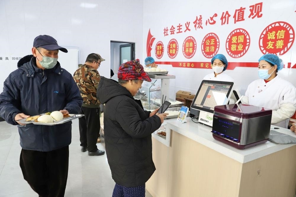 △2024年2月1日，市民在河北涿州市雙塔街道永濟秀園小區(qū)便民食堂內(nèi)購買午餐。