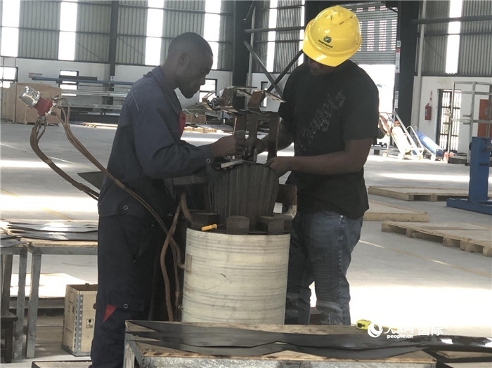 經(jīng)貿(mào)合作區(qū)廠房?jī)?nèi)，當(dāng)?shù)毓と苏诰o張作業(yè)。人民網(wǎng)記者 黃培昭攝