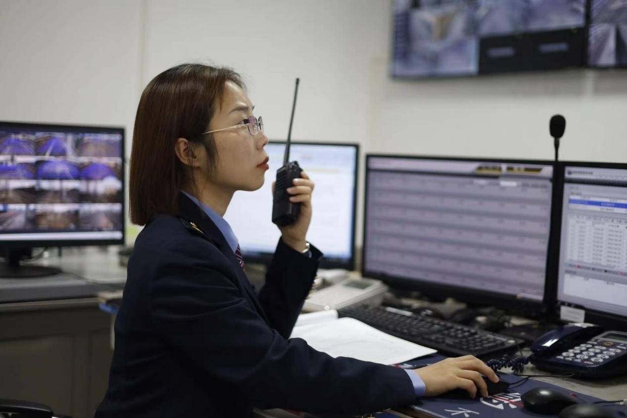 張華正在使用對(duì)講機(jī)溝通客運(yùn)工作情況。蔡紫妍攝