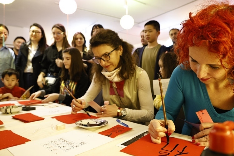 羅馬尼亞觀眾學習用毛筆寫“?！弊?。中國文化中心供圖