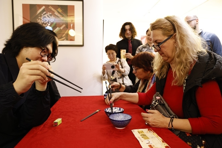 羅馬尼亞觀眾體驗用筷子夾花生。中國文化中心供圖