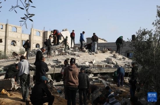  3月3日，在加沙地帶南部城市拉法，人們查看被以軍空襲破壞的建筑。新華社發(fā)（哈立德·奧馬爾攝）