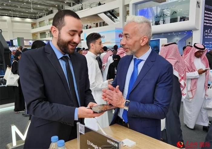 兩名觀眾在榮耀手機(jī)展臺前交流。人民網(wǎng)記者 管克江攝