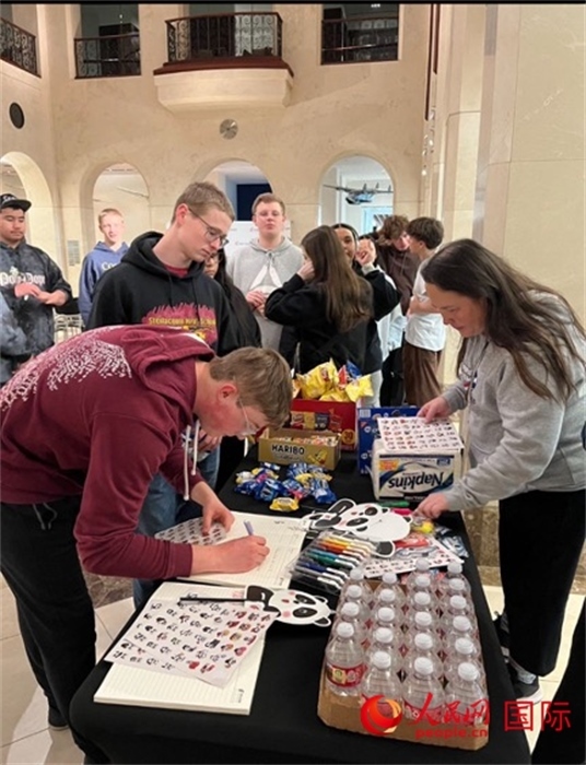 學(xué)生們出發(fā)前紛紛在留言簿留言。人民網(wǎng)記者 鄧圩攝