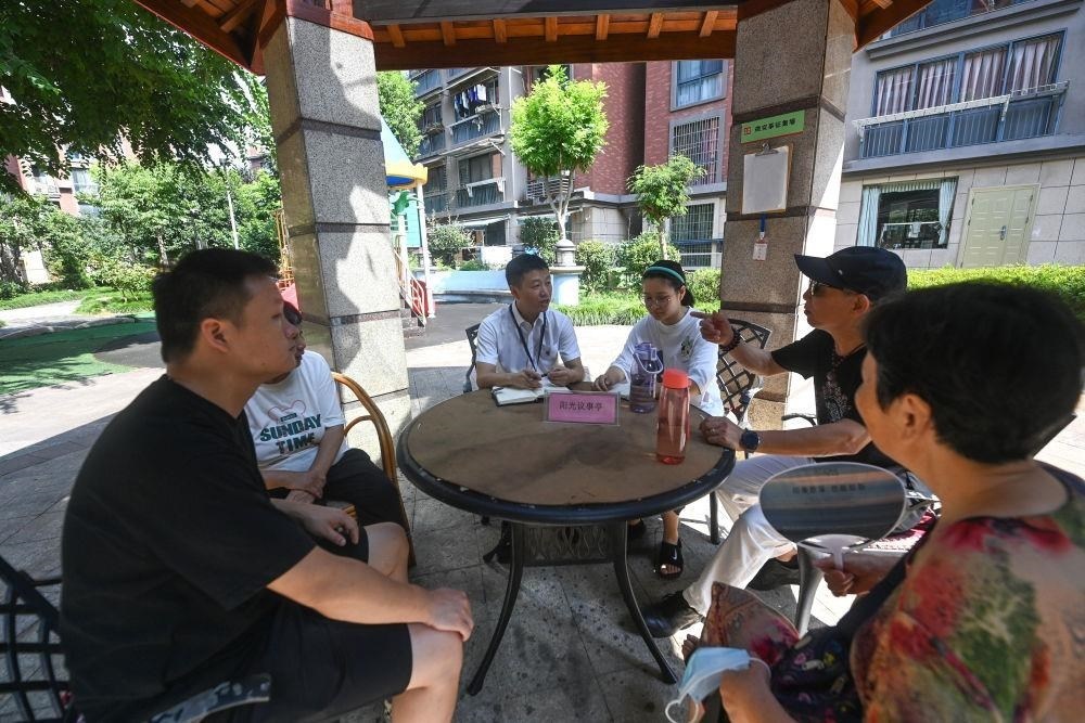 △2023年7月21日，在位于浙江杭州臨安區(qū)錦南街道水岸陽光小區(qū)的陽光議事廳，街道干部在聽取居民們反映的問題及意見。