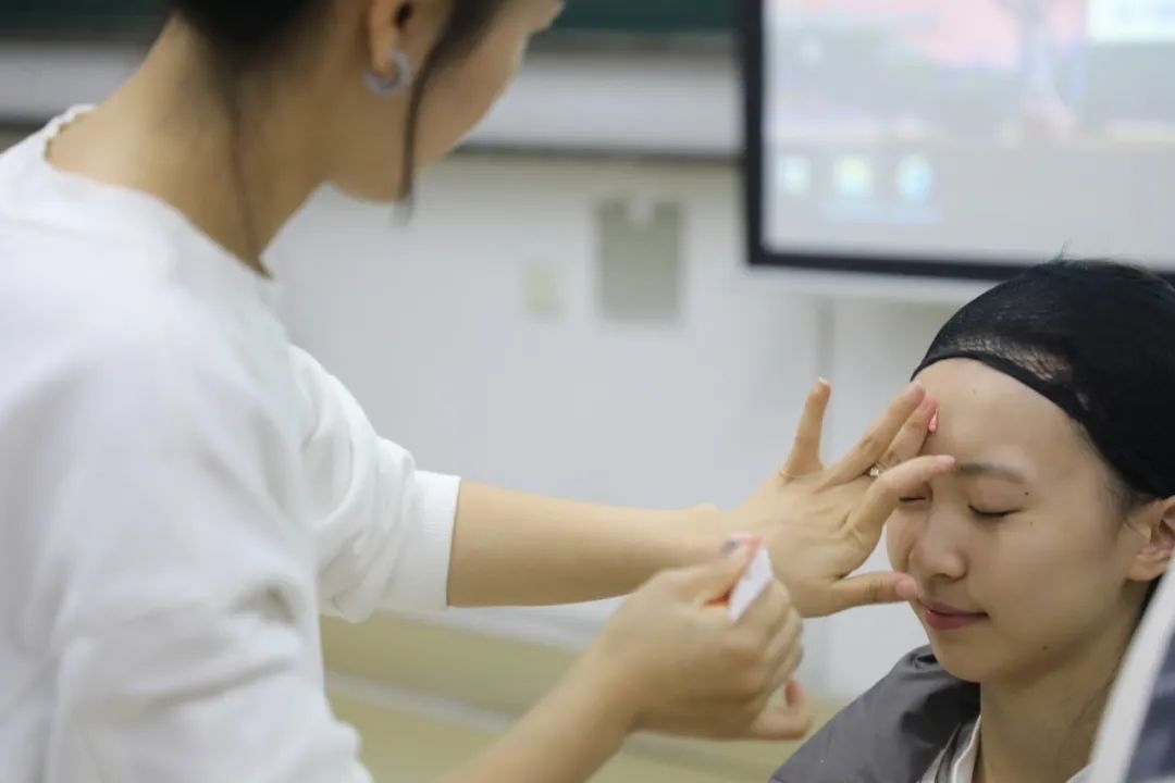 課堂上，一名學(xué)生在體驗(yàn)上戲妝。學(xué)校供圖