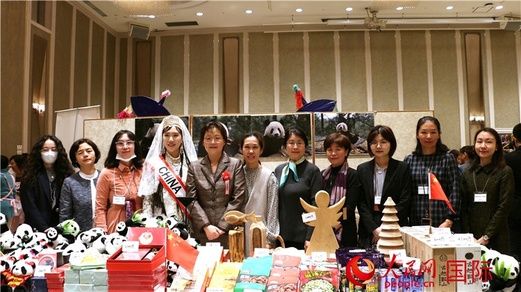 中國(guó)駐日本大使吳江浩夫人丁玥（左五）與使館人員在展位前合影留念。人民網(wǎng) 許可攝