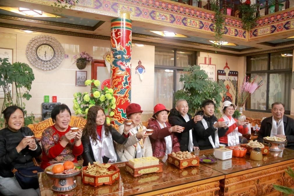 游客們?nèi)胱∶袼藓螅e杯共飲酥油茶。新華社記者 邱星翔 攝