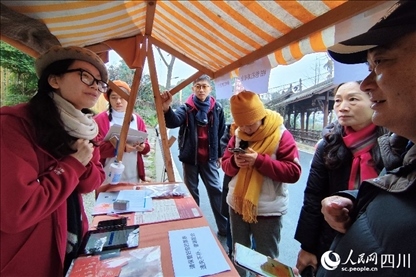 1月6日，“2024成都蒲江柑甜采摘節(jié)”上，記者見到了小萌（左一）和許多年輕人忙著做訪客接待、現(xiàn)場布置、票務(wù)核對、采摘服務(wù)等工作。人民網(wǎng)記者朱虹攝