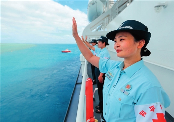 中國海軍“和平方舟”號醫(yī)院船結束訪問湯加時，任務官兵中的文職人員向歡送人群揮手告別（2023年8月4日攝）。徐巍攝/本刊