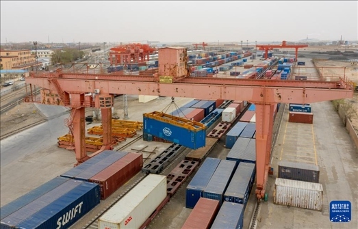 4月21日，二連浩特鐵路口岸龍門(mén)吊吊裝中歐班列集裝箱（無(wú)人機(jī)照片）。 新華社發(fā)（張海峰攝）