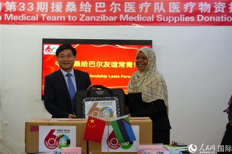 江蘇省蘇北人民醫(yī)院黨委書記束余聲捐贈物資與桑衛(wèi)生部首席秘書哈比巴。中國援桑醫(yī)療隊供圖