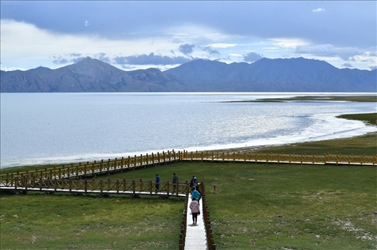 △ 游客行走在青?，敹嗫h冬格措納湖畔的木棧道上。