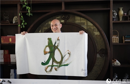 老撾駐華大使館三秘明君參加《五百筆·瀾湄合作》集體藝術創(chuàng)作。人民網(wǎng)王婧攝。