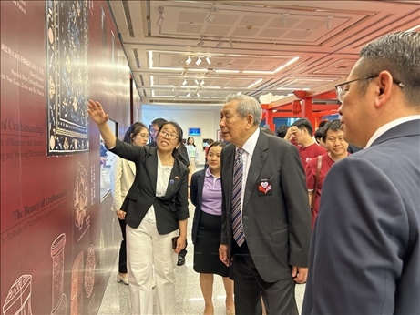 工作人員為泰國前副總理、泰中文化促進(jìn)委員會(huì)主席披尼講解展覽內(nèi)容。中國駐泰國大使館供圖