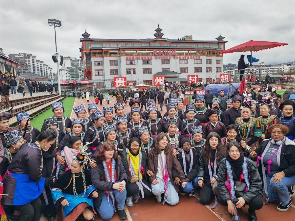 法國青年在“村超”賽場邊與參加表演的村民合影。新華社記者 羅羽 攝