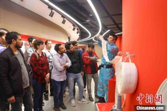 5月9日，工作人員指導(dǎo)留學(xué)生正確使用消防水帶。張鷹 攝