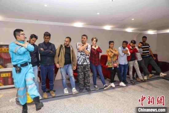 5月9日，工作人員指導(dǎo)留學(xué)生練習(xí)逃生技巧。張鷹 攝