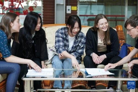 4月28日，宋智孝（右二）和胡靈月（左一）在北京首都師范大學校園內與同學交流。新華社記者 彭子洋 攝