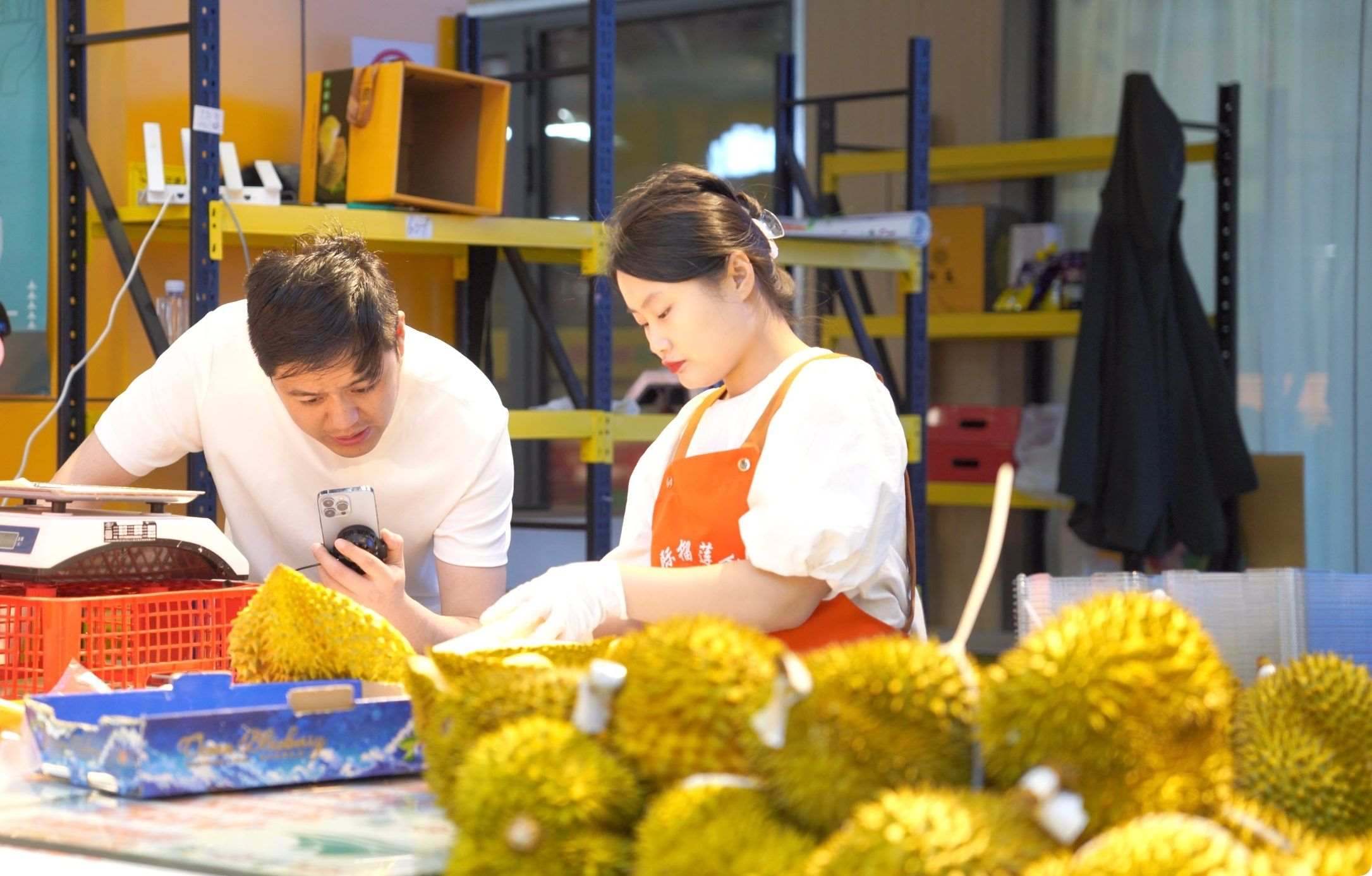 榴蓮商家正在通過(guò)手機(jī)直播銷(xiāo)售榴蓮。人民網(wǎng)記者申佳平 攝