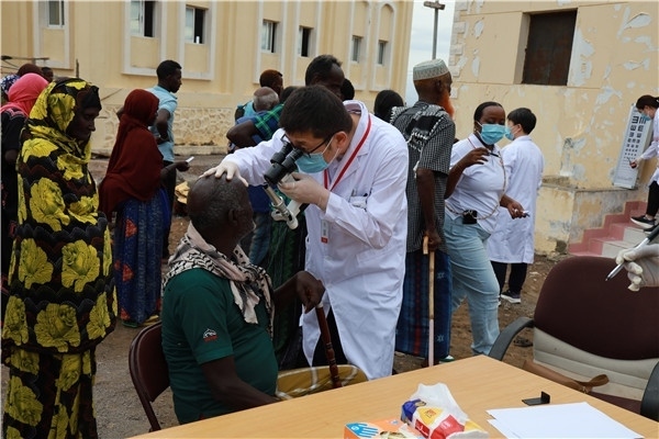 在義診現(xiàn)場(chǎng)，中國(guó)醫(yī)生與當(dāng)?shù)鼐用窈嫌傲裟?，吉布提鹽業(yè)投資公司供圖