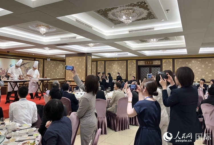 國家級非物質(zhì)文化遺產(chǎn)、全聚德片鴨工藝吸引代表團(tuán)成員拍照留念。