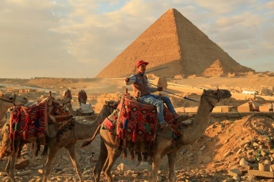 1月24日，商販騎駱駝離開埃及吉薩金字塔景區(qū)。新華社記者 隋先凱 攝