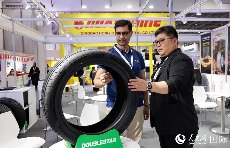 工作人員向客戶(hù)展示雙星電動(dòng)汽車(chē)輪胎。和傳統(tǒng)汽車(chē)輪胎相比，電動(dòng)汽車(chē)輪胎具有更高承載能力、更加靜音舒適、更好極速抓地、更低滾動(dòng)阻力等特點(diǎn)。人民網(wǎng)記者 管克江攝