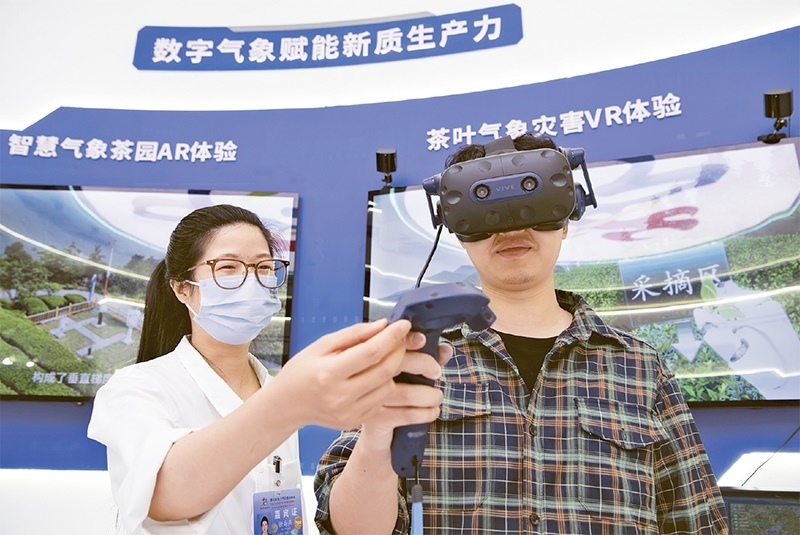 2024年5月23日，第七屆數(shù)字中國建設(shè)峰會現(xiàn)場體驗區(qū)在福州海峽國際會展中心向?qū)I(yè)觀眾開放。本次現(xiàn)場體驗區(qū)圍繞本屆峰會主題“釋放數(shù)據(jù)要素價值，發(fā)展新質(zhì)生產(chǎn)力”，設(shè)置“數(shù)字惠民”、“數(shù)字能力”、“數(shù)字基礎(chǔ)”、“數(shù)字生態(tài)”、“數(shù)字賦能”五大板塊。圖為一名觀眾（右）在數(shù)字氣象賦能新質(zhì)生產(chǎn)力展臺上進行體驗。 新華社記者 魏培全/攝