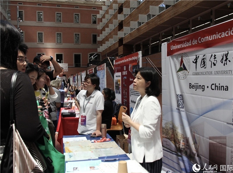 旅西華人華僑在展臺前咨詢。人民網記者 許海林攝