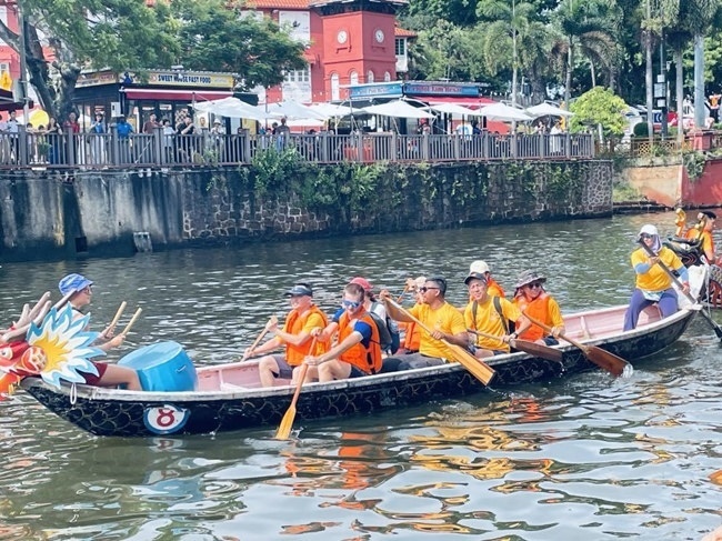 多元種族共同奮輯前進，體驗在馬六甲河劃龍舟，引來大批游客駐足圍觀。組委會供圖