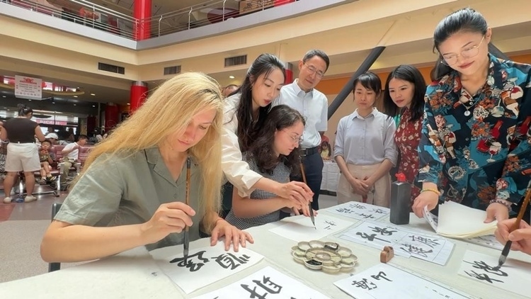 羅馬尼亞友人在活動(dòng)現(xiàn)場學(xué)寫漢字。中國駐羅馬尼亞大使館領(lǐng)僑處供圖