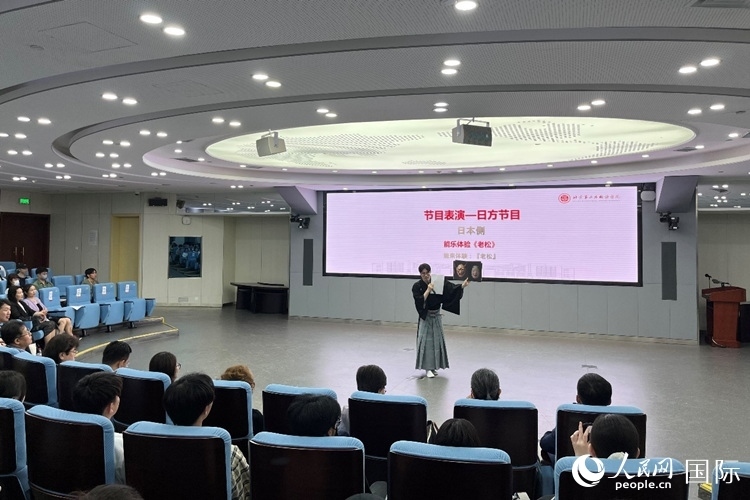 日本大學(xué)生介紹能樂知識。人民網(wǎng)記者 陳思攝