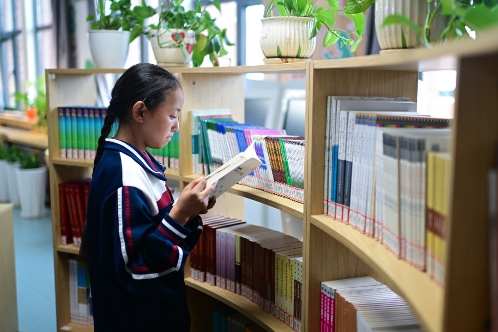 6月18日，果洛西寧民族中學(xué)學(xué)生尼東拉毛在圖書室看書。